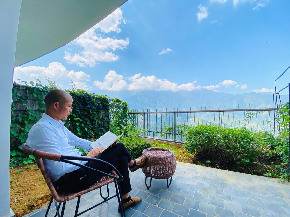 パオス サパ レジャー ホテル エクステリア 写真 A man reading a book on a balcony